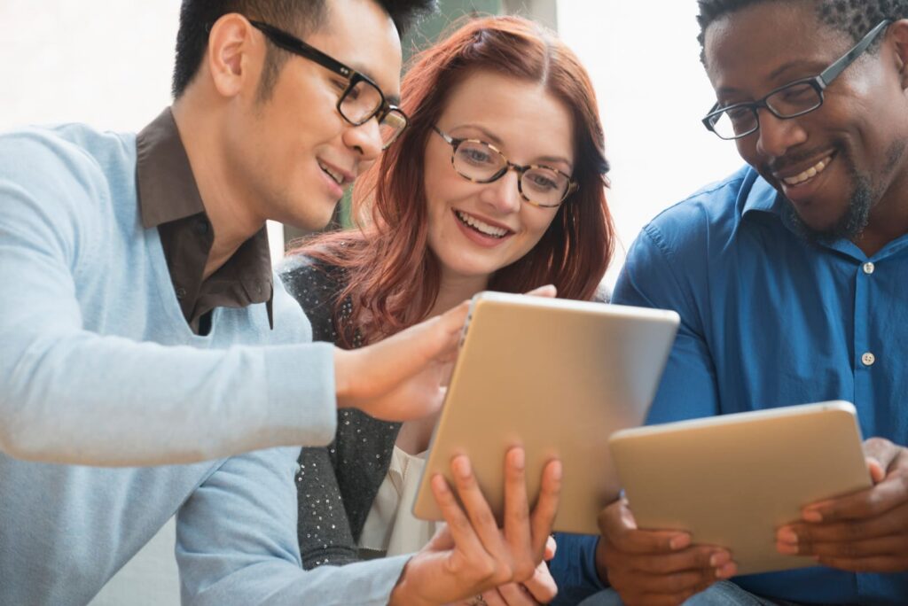 Co-workers sitting at a desk looking at a laptop