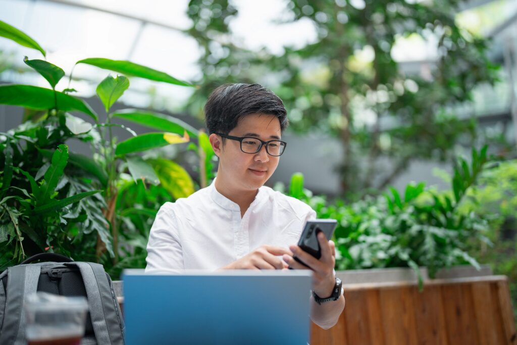 Image of community association manager reviewing payments using laptop and cell phone